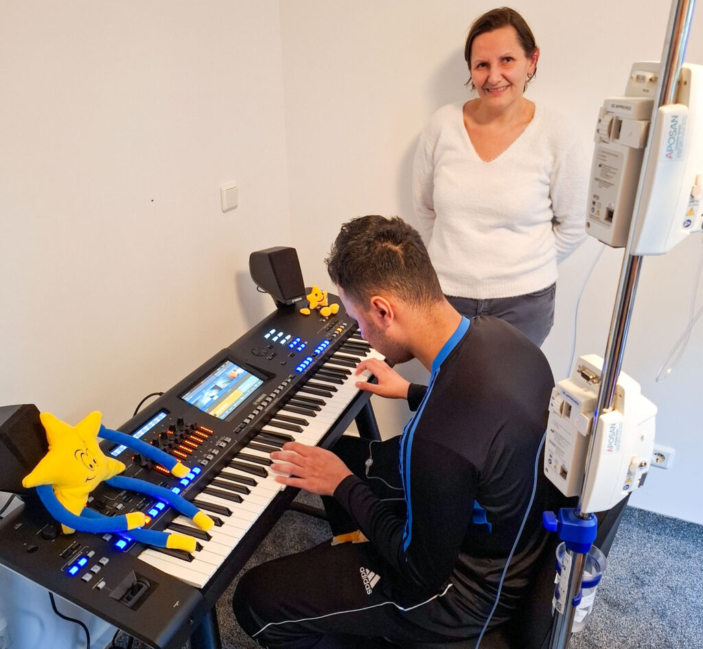 Ein Wunschkind spielt auf seinem neuen Keyboard. Karina Weiß lauscht aufmerksam