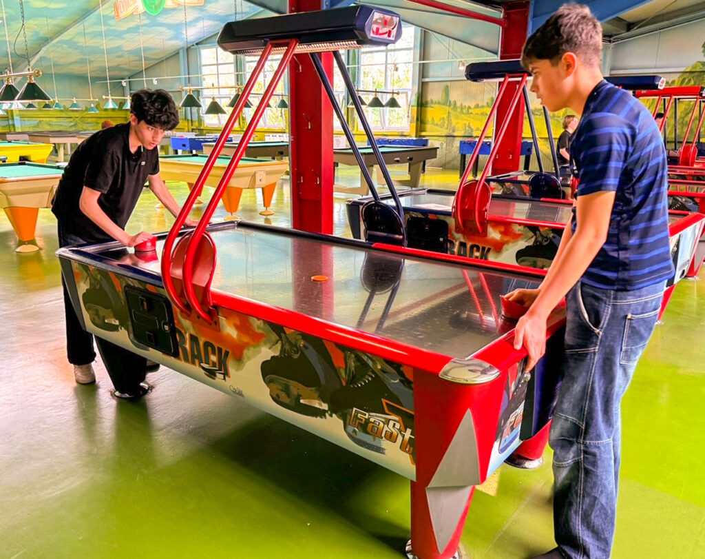 Zwei Teenager spielen Airhockey.
